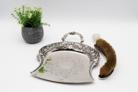 Apanha-migalhas e escova em prata com relevos, gravados de folhas e flores